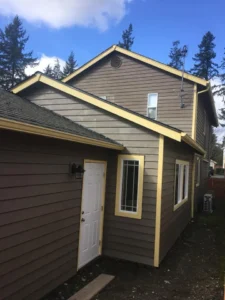 house with brown siding and yellow trim