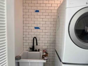 laundry-sink area with unfinished tile work